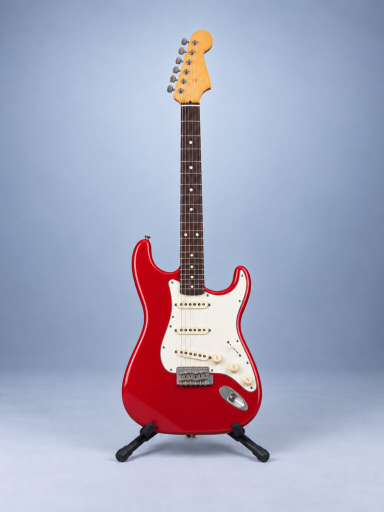The same guitar refinished in glossy red, with no chips or bare wood.
